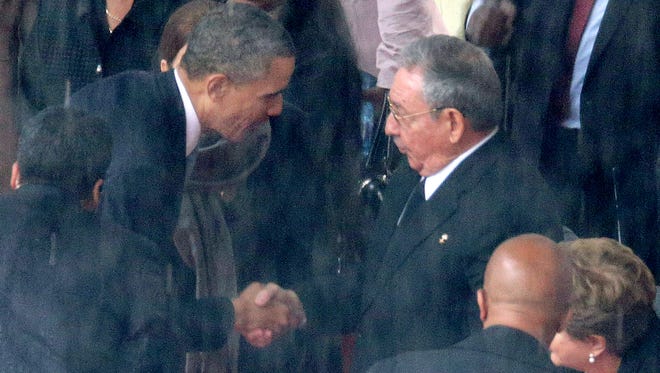 U.S. President Barack Obama shakes hands with Cuban President Raul Castro during the official memorial service for former South African President Nelson Mandela at FNB Stadium in Johannesburg, South Africa.