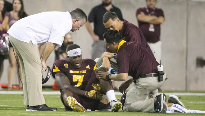 ASU running back Kalen Ballage reacts to an injury as ASU head coach Todd Graham stands over him during the first quarter of the college football game at Sun Devil Stadium in Tempe on Saturday, September 24, 2016.
