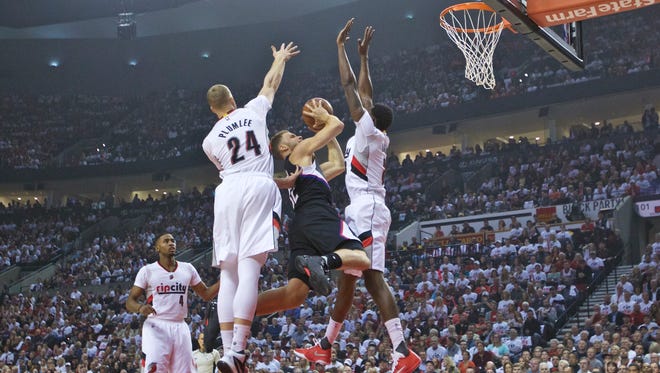 Los Angeles Clippers forward Blake Griffin, center, shoots over Portland Trail Blazers center Mason Plumlee, left, and forward Al-Farouq Aminu, right, during the first half of Game 4 of an NBA basketball first-round playoff series Monday, April 25, 2016, in Portland, Ore. (AP Photo/Craig Mitchelldyer)