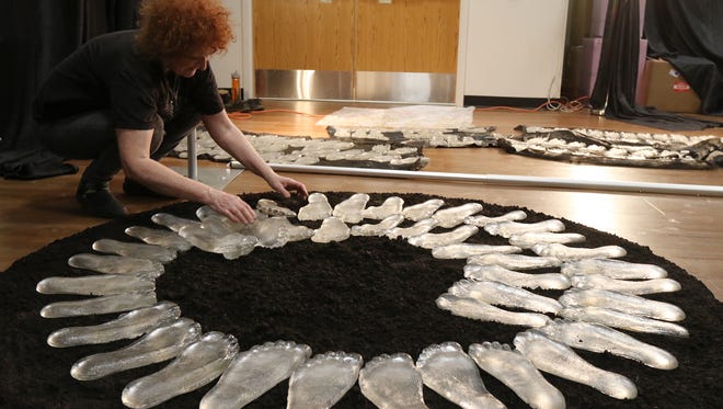 Laura Donefer of Harrowsmith, Ontario, Canada, sets up her exhibit, Todesmarche Revisited, at the Louis S. Wolk JCC of Greater Rochester.  The exhibit will have a path of burnt feet, the plaster cast feet, leading into a tower of glass feet.  The darker feet represent the nameless who died in the Holocaust death march with it leading into tower of clear glass feet that represents hope.