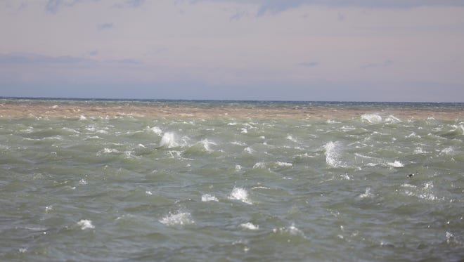 Lake Ontario’s waves are peppered with white caps.
