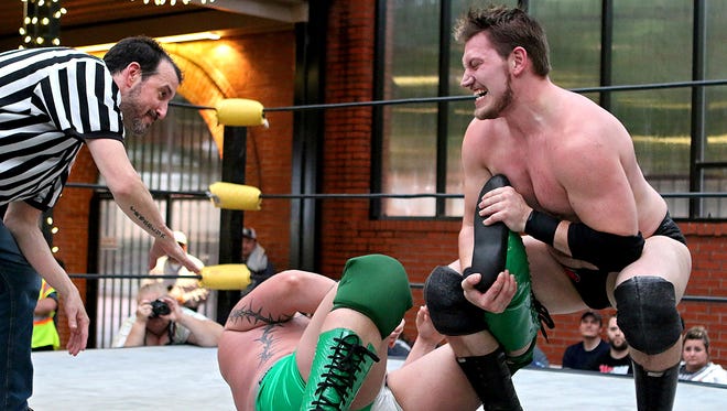 Jake Logan twists the leg of Exile while applying a submission Friday night at the Wichita Falls Wrestling Association's Wrestling Under the Stars II in the Downtown Wichita Falls Farmers Market.