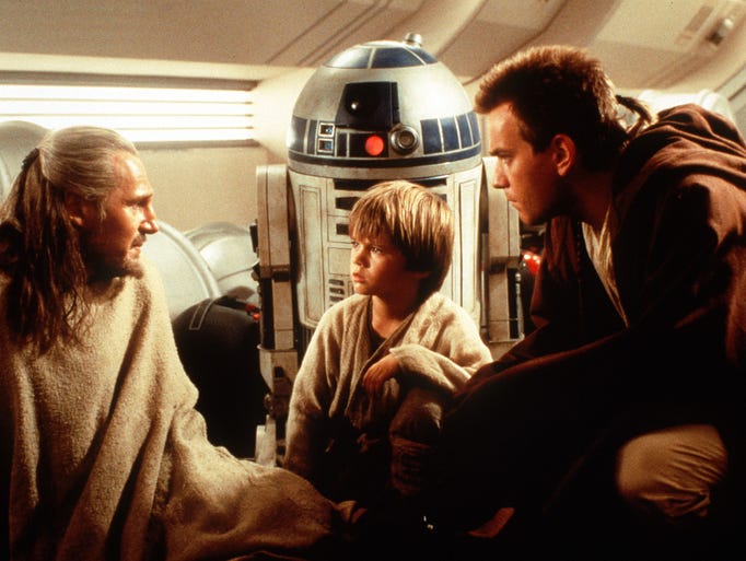 Liam Neeson, Jake Lloyd and Ewan McGregor  in a scene