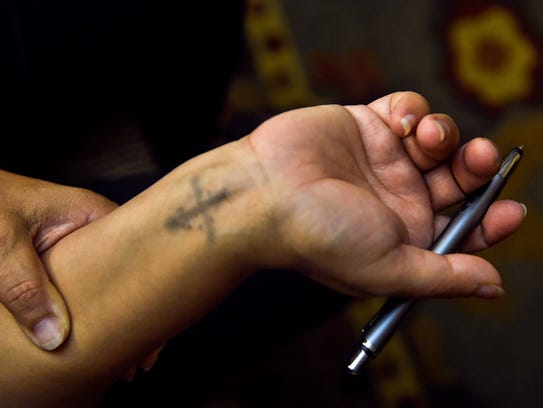 Ragaa Thabet shows a Coptic cross tattooed on her wrist.