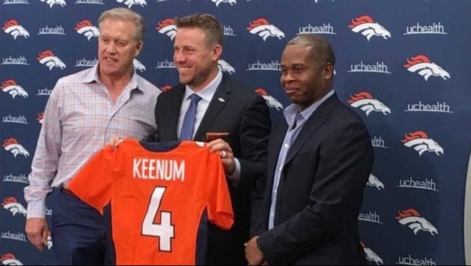 Case Keenum is flanked by Denver Broncos GM John Elway, left and head coach Vance Joseph.