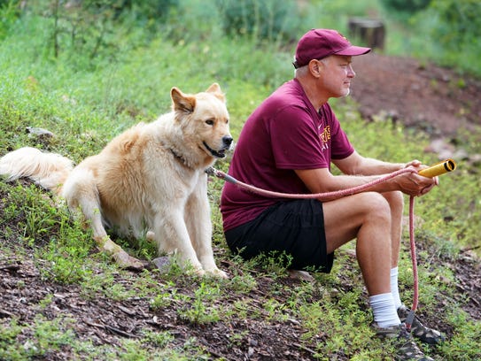 Todd Verch and his dog Dakota watches the Arizona State