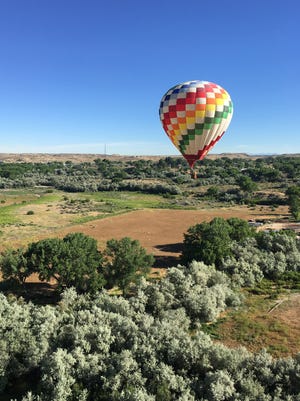 A hot air balloon flies west from Bloomfield during the 2017 San Juan River Balloon Rally.