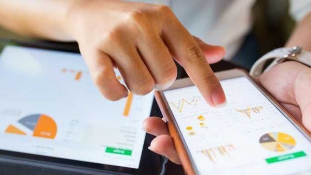 A phone and a tablet are shown with charts on...