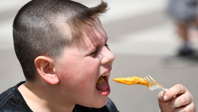 Collin Blake, 8 years-old, preparing to chomp on some cheese fries at the 31st annual Henderson Breakfast Lions Club Tri-Fest Saturday, April 21, 2018.