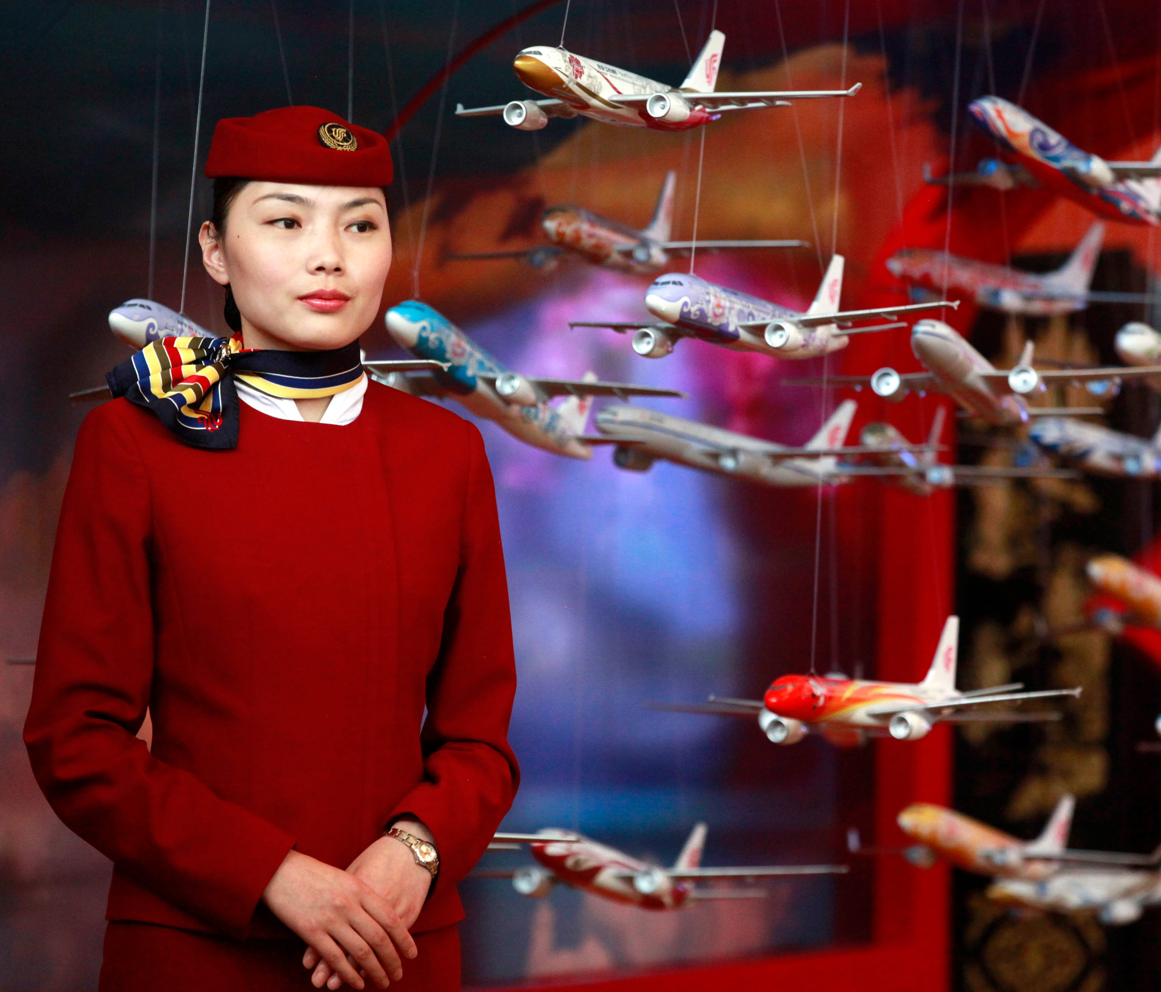 In this file photo from June 12, 2012, an Air China flight attendant stands near model planes at the International Air Transport Association (IATA) 68th Annual General Meeting (AGM) and World Air Transport Summit in Beijing.