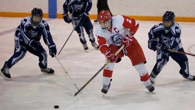 Marysville players put pressure on Port Huron senior Will Kriewall during a hockey game this season.