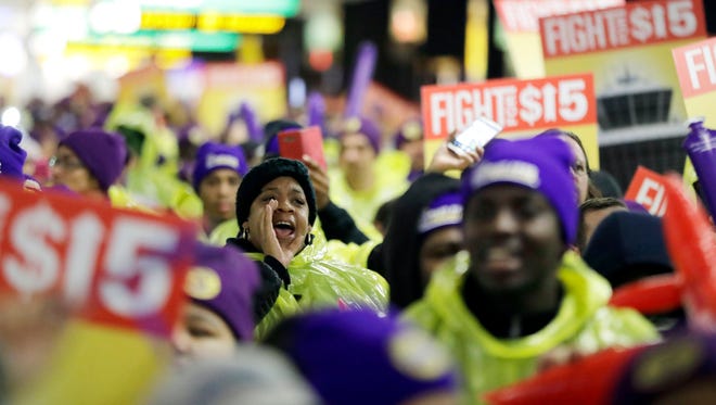 A woman shouts while marching with service workers asking for $15 minimum wage pay during a rally at Newark Liberty International Airport, Tuesday, Nov. 29, 2016, in Newark, N.J. The event was part of the National Day of Action to Fight for $15. The campaign seeks higher hourly wages, including for workers at fast-food restaurants and airports. (AP Photo/Julio Cortez)