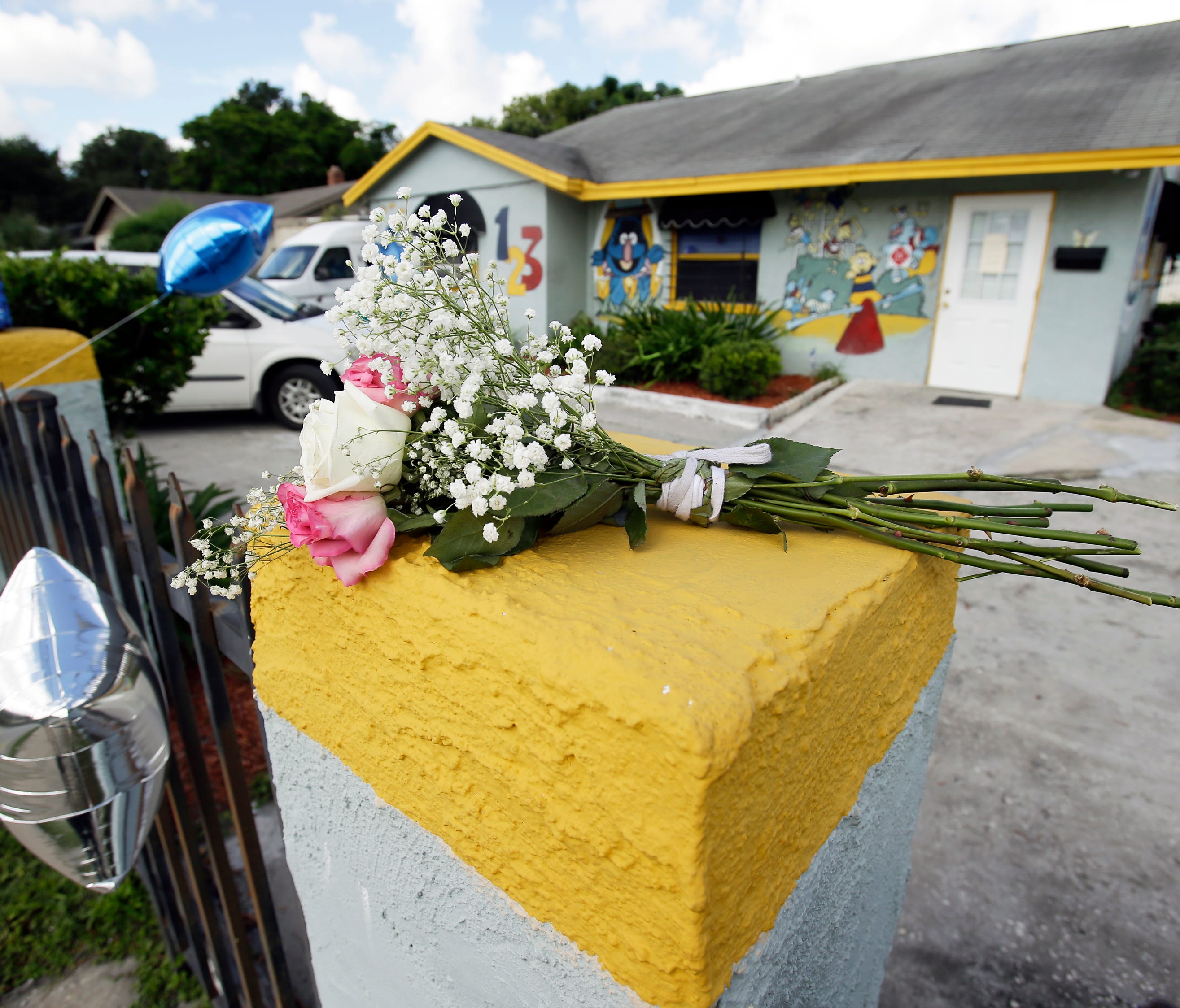 Flowers and balloons are left outside at a makeshift memorial Tuesday, Aug. 8, 2017, in Orlando, Fla., in front of a day care center where a young boy was found dead after being left in a van.
