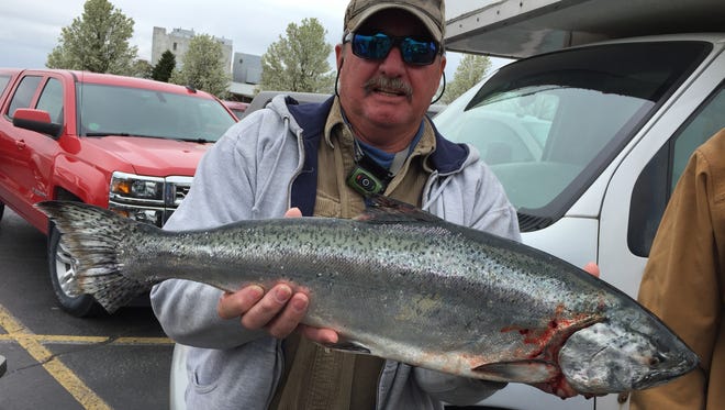 Eric Hutchinson, of Columbus Township, holds a king salmon he caught while fishing aboard True Lies during the Salmon Stakes.
