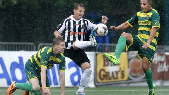 Doug Miller, center, chips the ball while defended by Carlos Zavala, right, and Joe Mercik during Rhinos Legends Match played at Sahlen's Stadium on Saturday. Team Andracki defeated Team Demmin 2-1. ADRIAN KRAUS