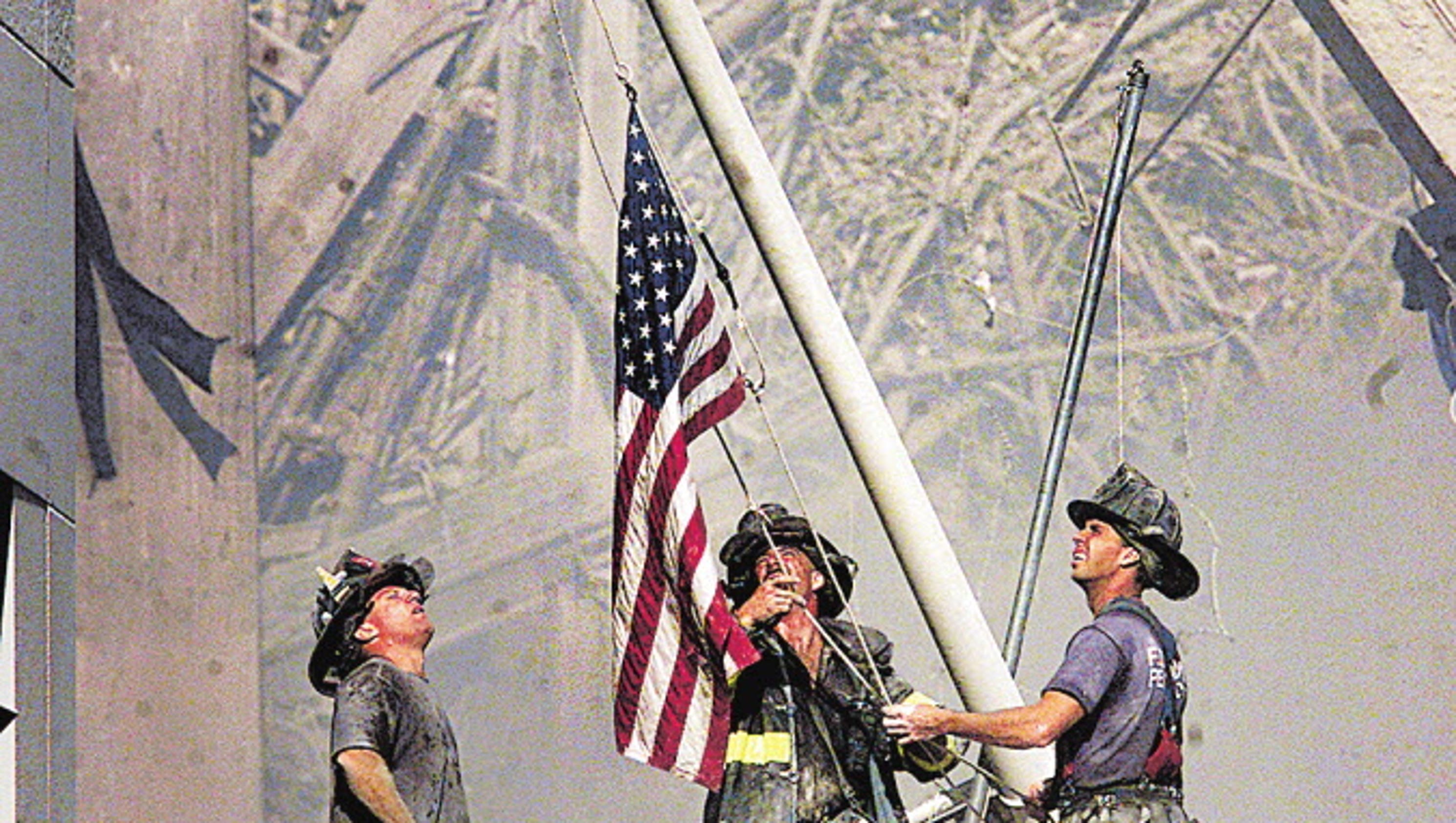 636403029350259129-Firefighters-raise-flag-Sept-11.jpg
