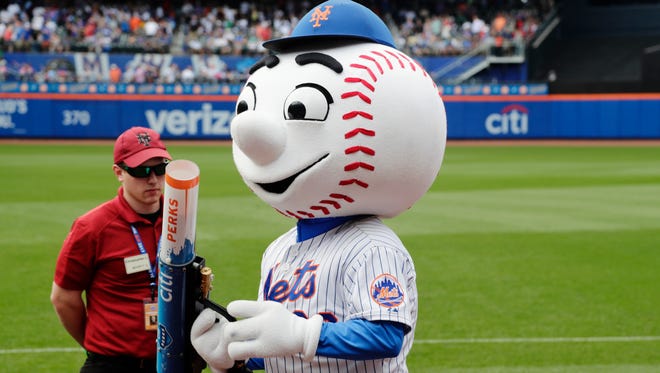 Mr. Met, left, distributes T-shirts to fans Thursday during the Mets-Brewers game in New York. The previous day, the person inside the costume was caught on video making an obscene gesture toward a fan. The Mets said that employee would not be the mascot again.