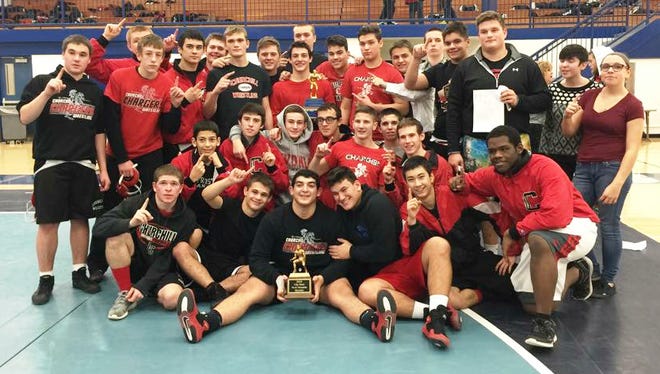Members of the Livonia Churchill wrestling team pose with their Livonia City Meet first-place trophy Wednesday night.
