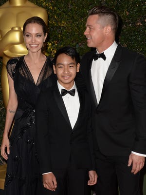 Maddox Jolie-Pitt walks the red carpet with his parents Angelina Jolie and Brad Pitt in 2013.