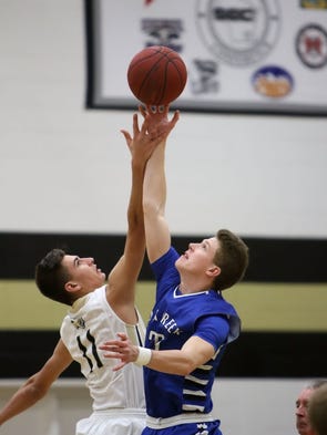 Oak Creek's Drew Yetka (right) leaps for the tip in