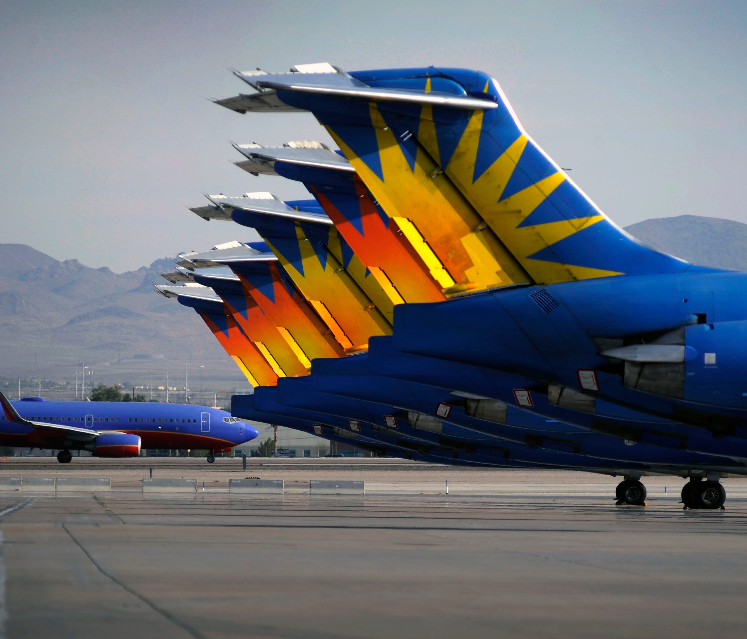 A Southwest Airlines plane taxis by parked Allegiant Air jetliners at McCarran International Airport in Las Vegas on May 9, 2013.