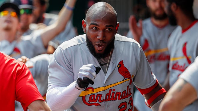 St. Louis Cardinals' Marcell Ozuna celebrates in the dugout after hitting a solo home run off Cincinnati Reds starting pitcher Luis Castillo in the first inning of a baseball game, Saturday, June 9, 2018, in Cincinnati. (AP Photo/John Minchillo)
