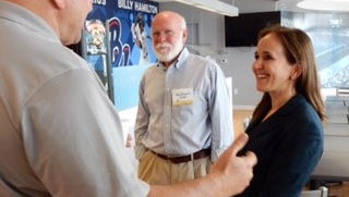 Sam Mathews, a psychology professor at the University of West Florida, looks on as author Dana Suskind talks with Peter Nowak