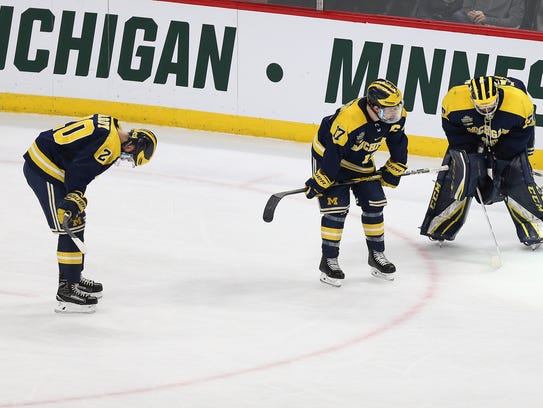 Michigan's Cooper Marody, Tony Calderone and Hayden Lavigne react to a 4-3 loss to Notre Dame in the semifinal in the NCAA men's hockey tournament on April 5, 2018, in St. Paul, Minn.