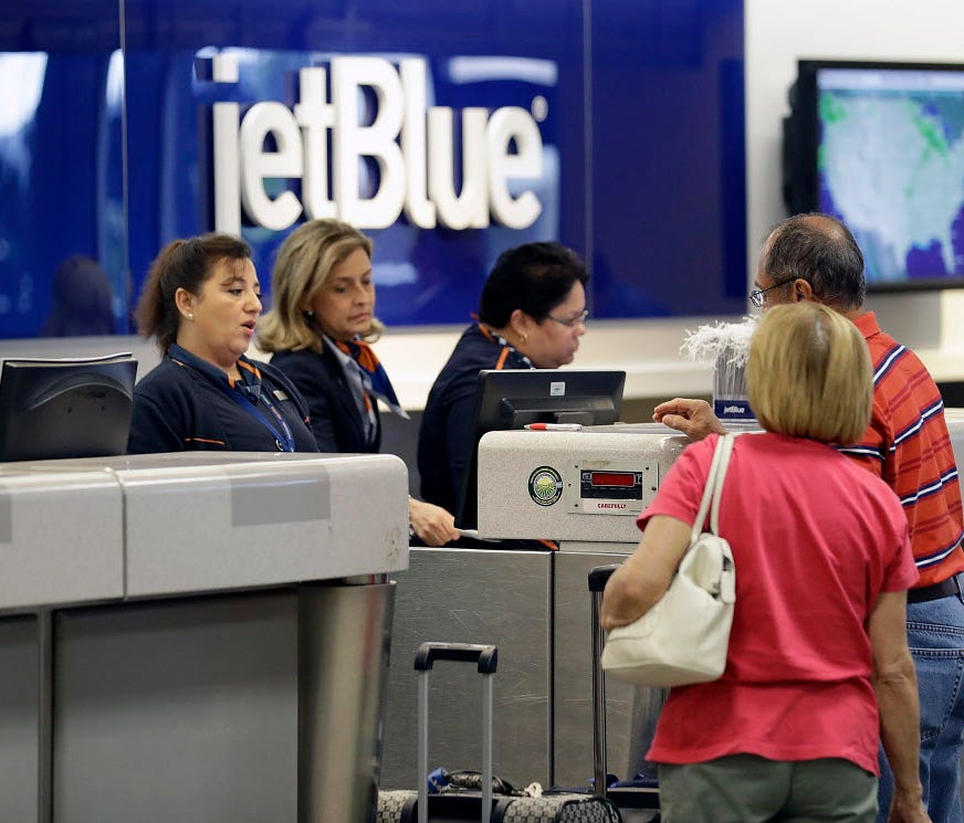 JetBlue Airways ticket agents assist passengers Oct. 26, 2016,  at the ticket counter at the Tampa International Airport in Tampa, Fla.