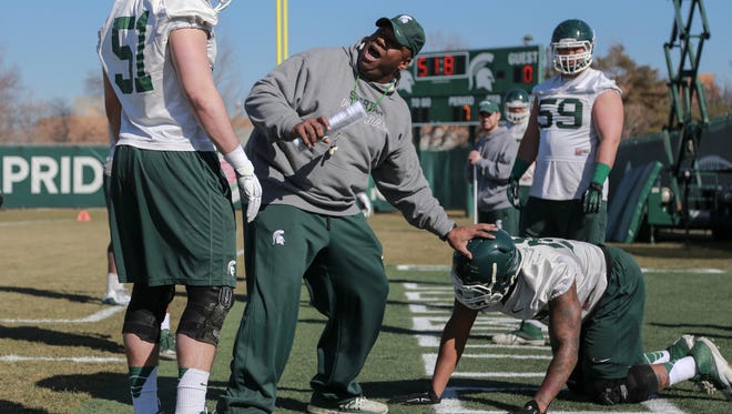 Defensive line coach Ron Burton explains a drill to defensive end Dillon Alexander (51) during the first spring practice of Michigan State University football team on Tuesday March 24, 2015 at the Duffy Daugherty Football Building on the Michigan State University campus in East Lansing.