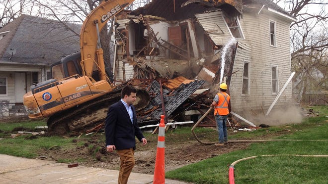 Bill Pulte Jr. walks in front of a Pontiac house being demolished by Pulte's nonprofit Detroit Blight Authority in April 2014.