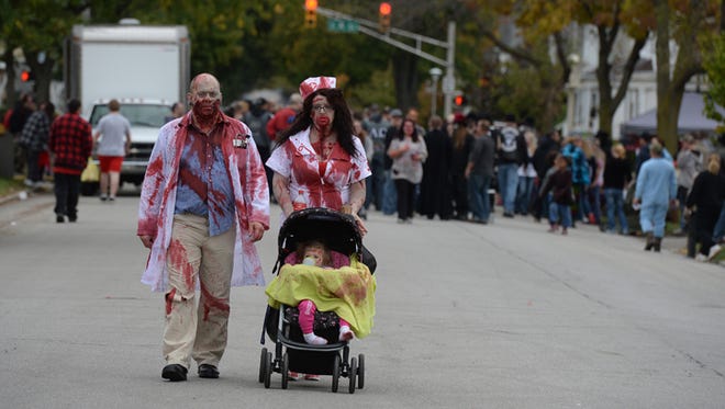 A family dressed for Richmond's Zombie Walk strolls down 12th Street in 2014. Each participant is to bring at least two nonperishable foods for local pantries.