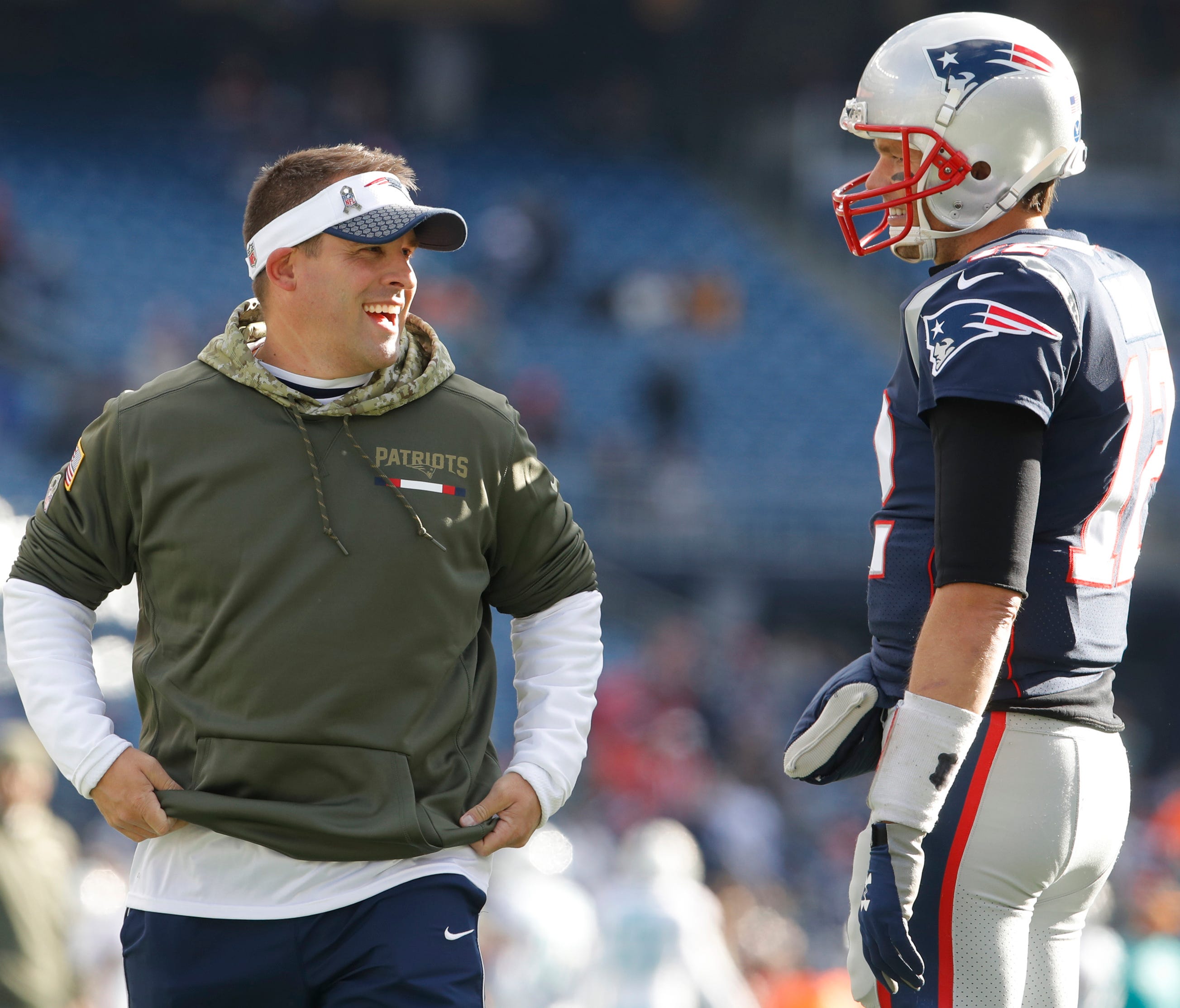 New England Patriots quarterback Tom Brady (12) talks with offensive coordinator Josh McDaniel before the game against the Miami Dolphins at Gillette Stadium.