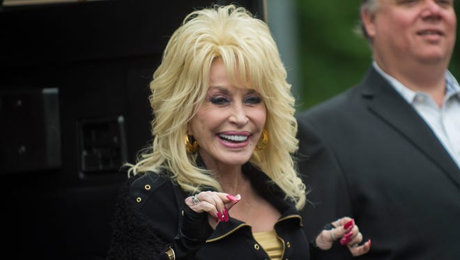Dolly Parton smiles and waves to fans as she steps off her tour bus and enters her new dinner show Smoky Mountain Adventures in Pigeon Forge on Friday, May 5, 2017.