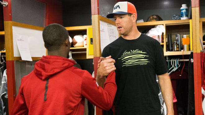 Arizona Cardinals receiver John Brown (left) greets quarterback Carson Palmer while both clean out their lockers at the team's training facility in Tempe, Ariz. on January 25, 2016.