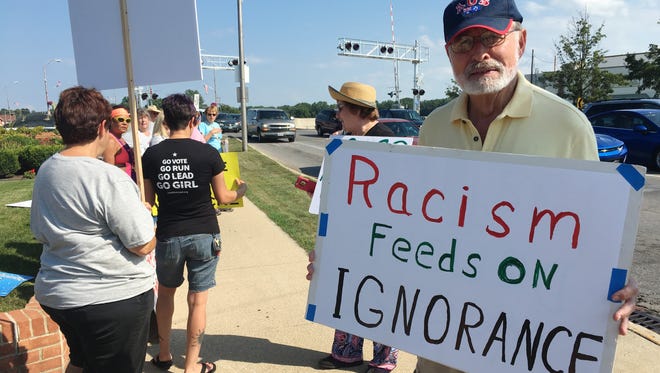Dave Pasch holds a sign denouncing racism at a Fremont rally denouncing Saturday's fatal attack in Charlottesville, Virginia.