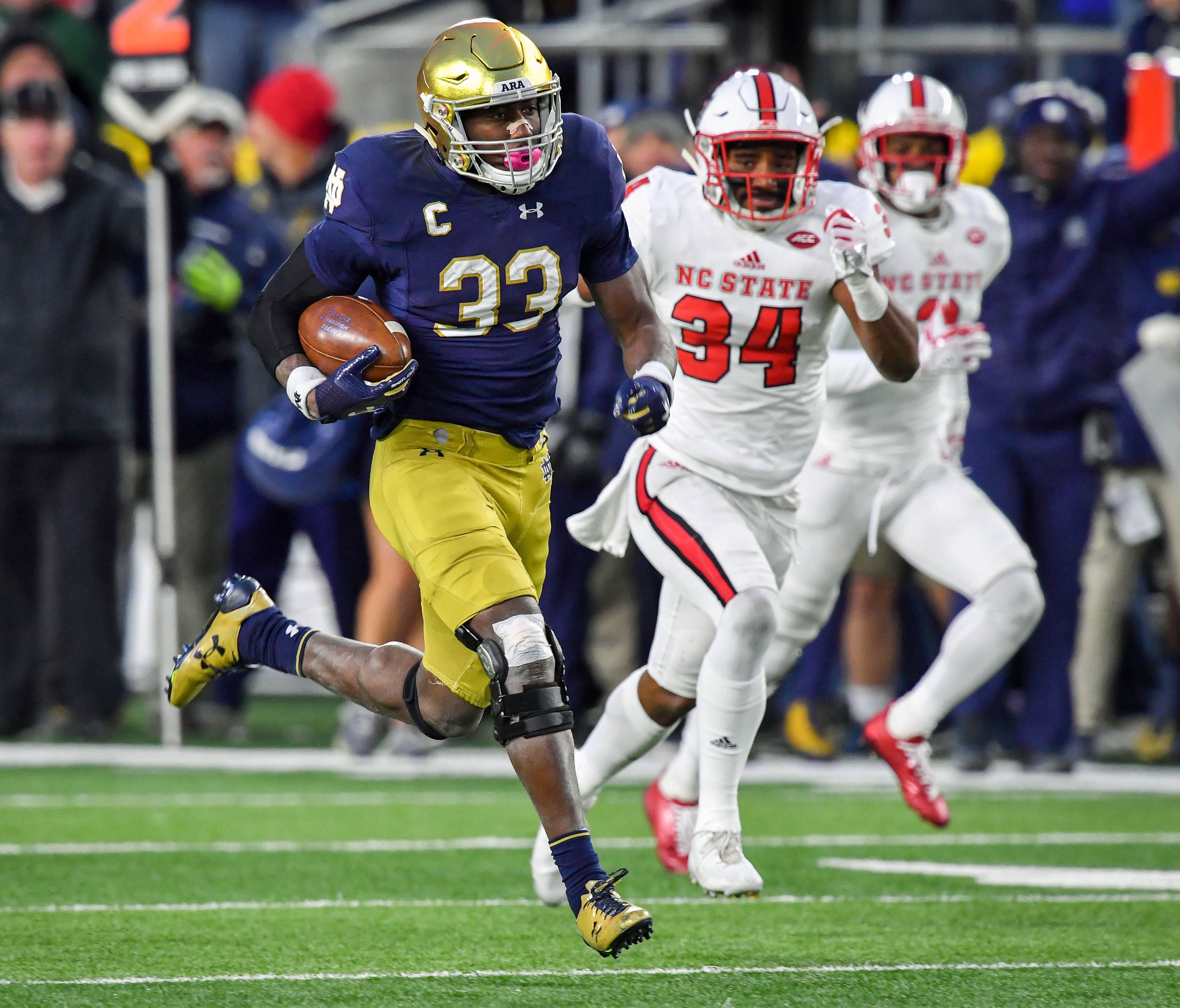 Notre Dame Fighting Irish running back Josh Adams (33) runs for a touchdown as North Carolina State Wolfpack safety Tim Kidd-Glass (34) pursues in the third quarter at Notre Dame Stadium.