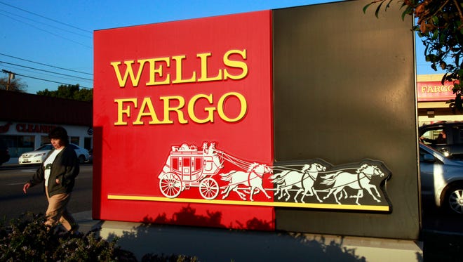 In this Jan. 18, 2011 file photo, a pedestrian walks by a Wells Fargo bank branch in Los Angeles.