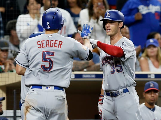 Los Angeles Dodgers' Corey Seager, left, gets congratulations from Cody Bellinger after hitting a solo home run during the fifth inning of a baseball game against the San Diego Padres in San Diego, Saturday, July 1, 2017. (AP Photo/Alex Gallardo)