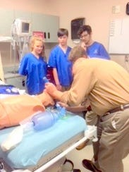 Students are shown how to clear an airway.