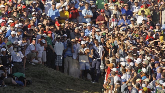 Surrounded by the gallery he hit into, Dustin Johnson hits his approach shot on No. 18 on Sunday, Aug. 15, 2010, during the final round of the PGA Championship at Whistling Straits. He was assessed a two-stroke penalty on the shot for grounding his club in a bunker.