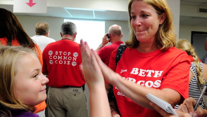 Williamson County school board candidate Beth Burgos celebrates early voting results with a high-five from Katie Curlee,12, at the Williamson County Admin. Complex on Aug. 7, 2014.