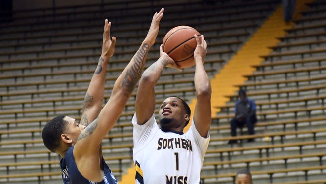 Southern Miss'  Cortez Edwards throws over a defender in a game against Old Dominion on Thursday in Reed Green Coliseum. 