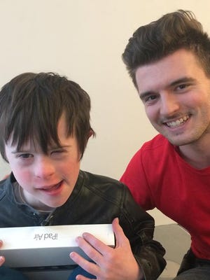 James Rink, 9, with Apple store worker Andrew Wall on the floor where James fell after smashing into a glass wall