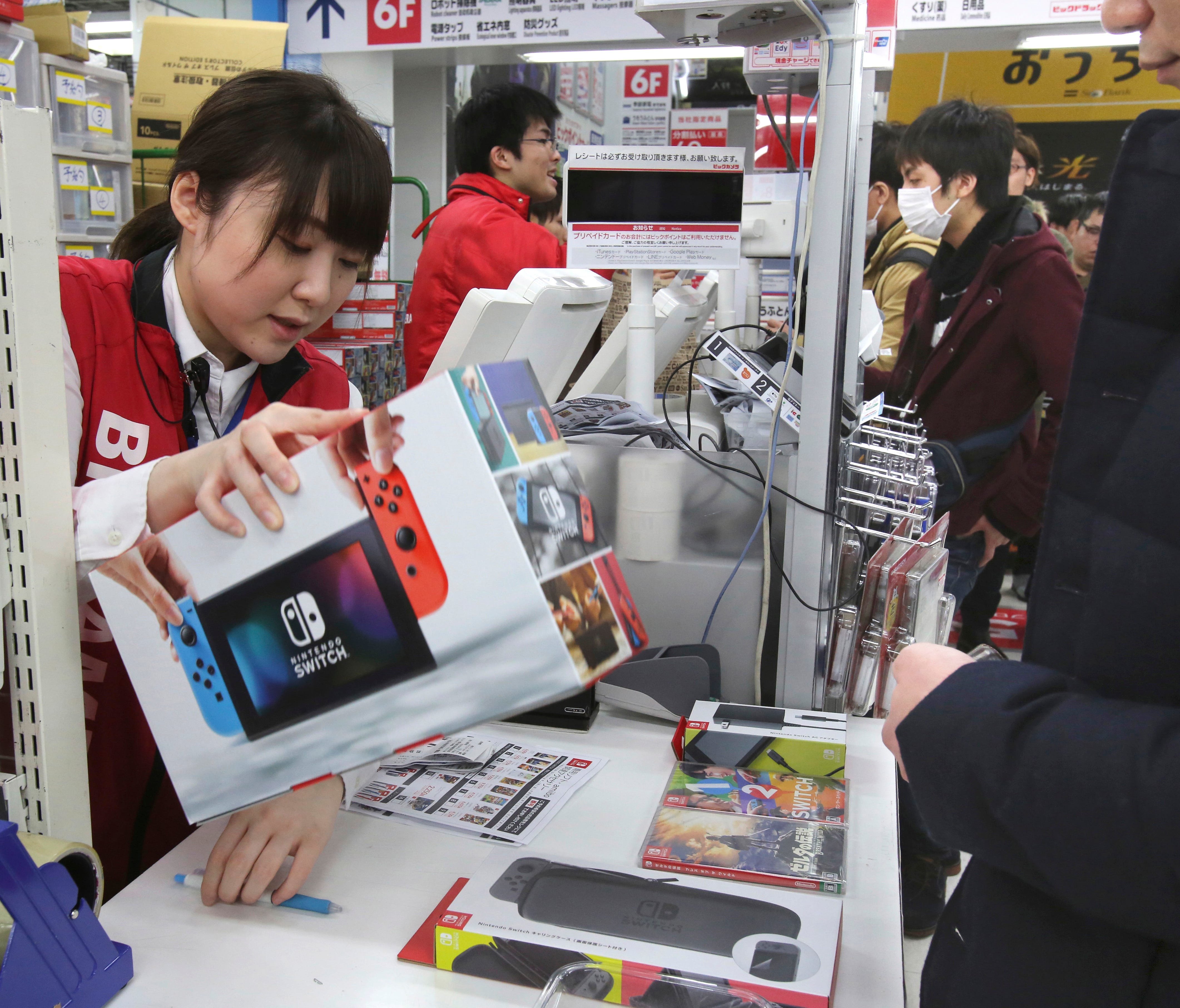 An employee of electronics retailer Bic Camera sells Nintendo's Switch video game console in central Tokyo.