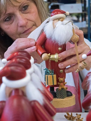 Toy maker Ute Seifert assembles a Santa Claus figure, a so-called 'Raeuchermann' (a wooden Christmas incense smoker) at the Arts and Craft Workshop in Olbernhau, eastern Germany, Wednesday, Dec. 17, 2014.