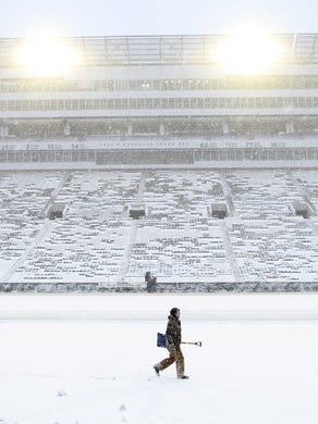 Workers clear snow off Kinnick Stadium's field on Saturday, Nov. 21, 2015.