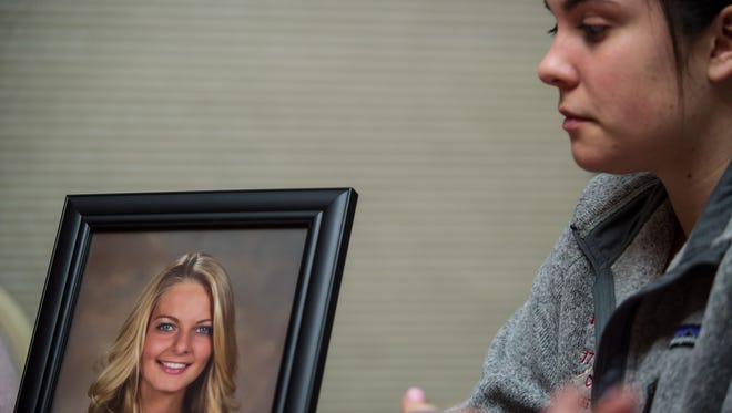 A portrait of Nicole Trott, stands in front of Katie Hungrige, a close friend of Nicole during a meeting hosted by Nicole's mother Pat Trott for Nicole's Heart Foundation at her home in Old Bridge on Feb. 5, 2016.