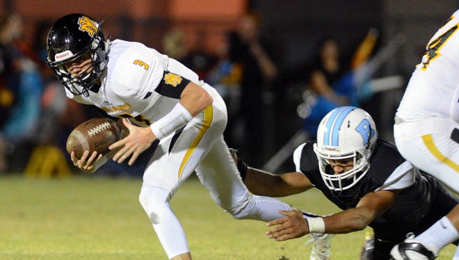 Merritt Island QB Jimmy Batch tries to escape from a Rockledge tackler during Friday's game at McLarty Stadium.