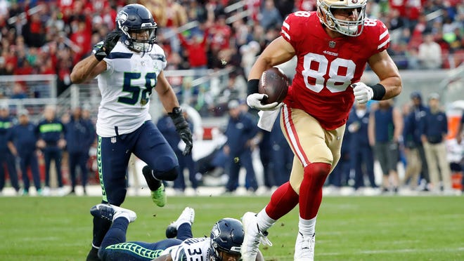 San Francisco 49ers tight end Garrett Celek (88) runs past Seattle Seahawks free safety Tedric Thompson (33) and outside linebacker Austin Calitro (58) to score against the Seattle Seahawks during the first half of an NFL football game in Santa Clara, Calif., Sunday, Dec. 16, 2018. (AP Photo/Tony Avelar)